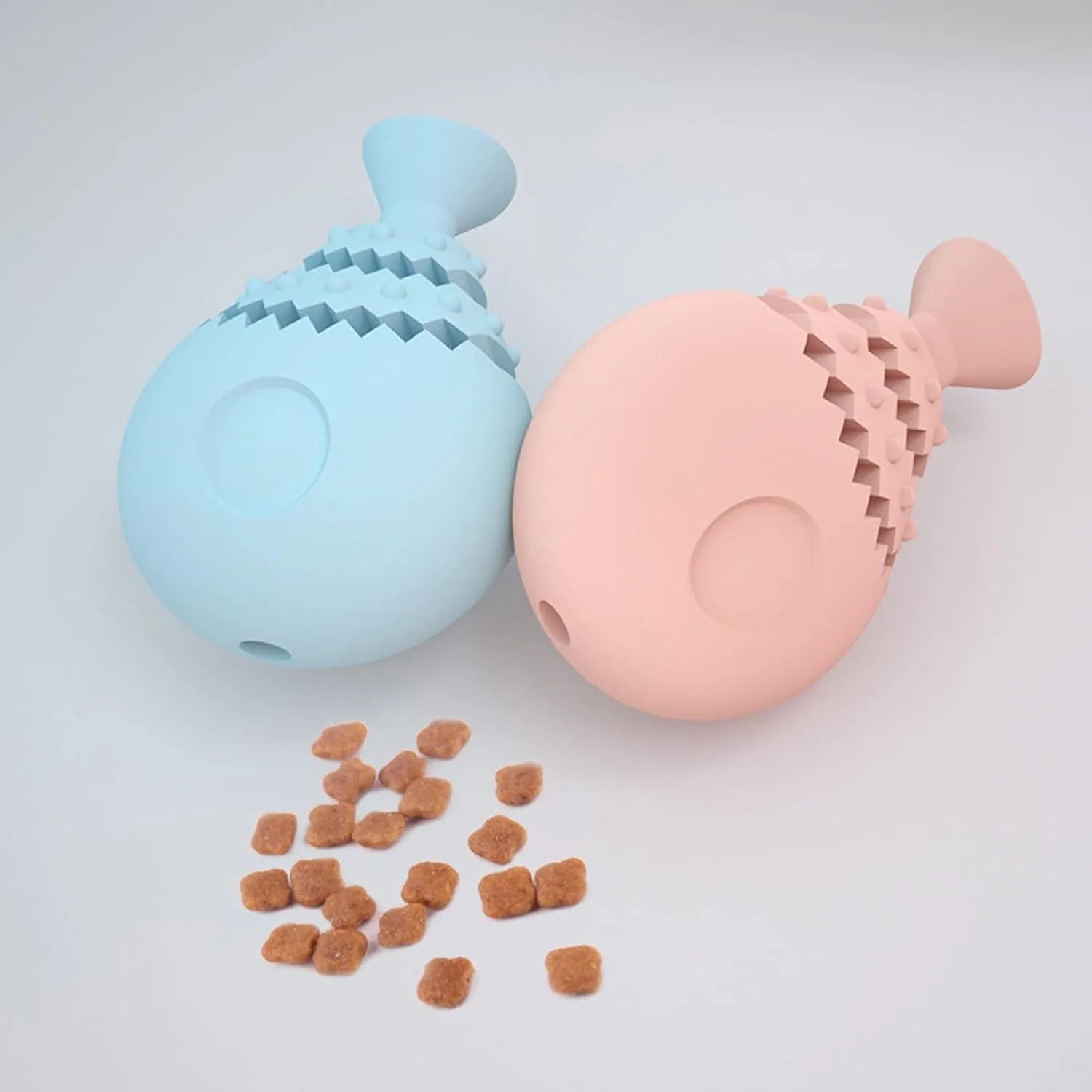 Blue fish bone shaped silicone dog chew toy with a treat hole, shown next to a green and pink version.