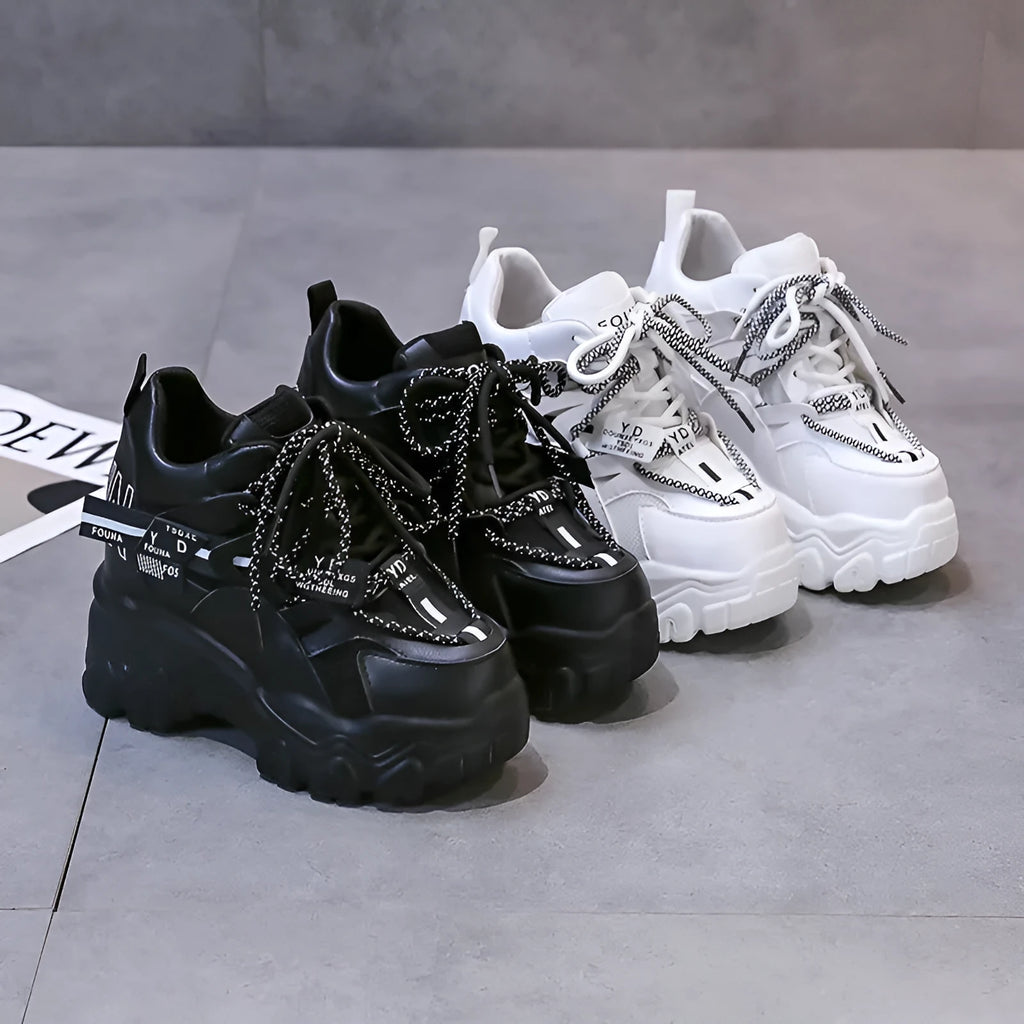 Women's white and black mesh platform tennis shoes with cross strap and thick rubber sole.