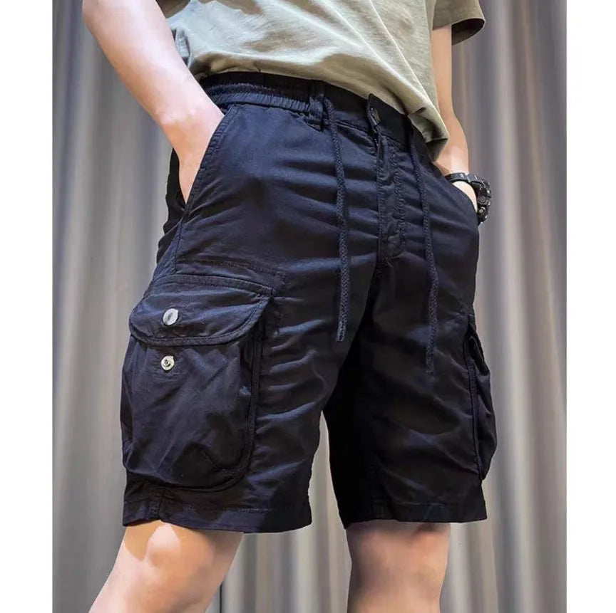 A model wearing loose straight-leg multi-pocket overalls in a khaki colour.