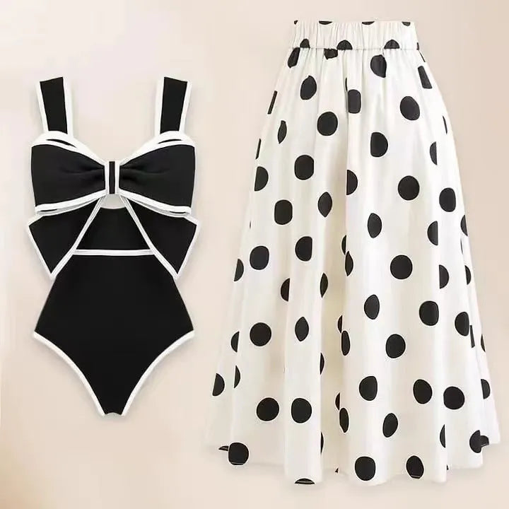 Women's black one-piece swimsuit with a white round skirt and a bow detail at the front.