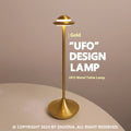 Metallic UFO-shaped desk lamp with touch controls in black finish on wooden surface