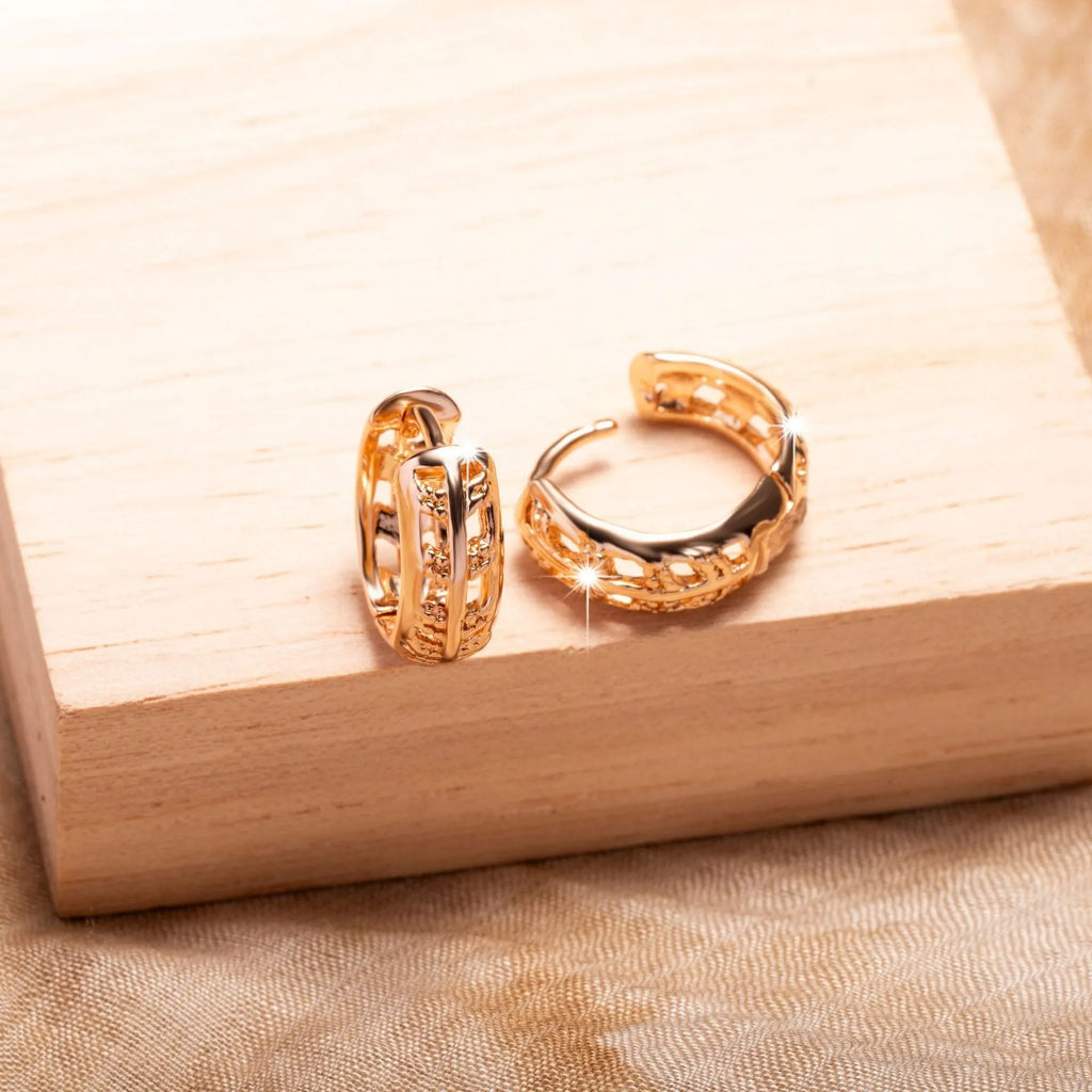 Small rose gold hollowed-out copper earrings with a leaf and a heart pendant design.
