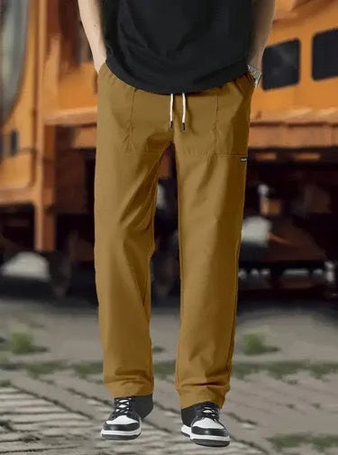 Men's polyester trousers for spring and autumn in light grey, shown flat.