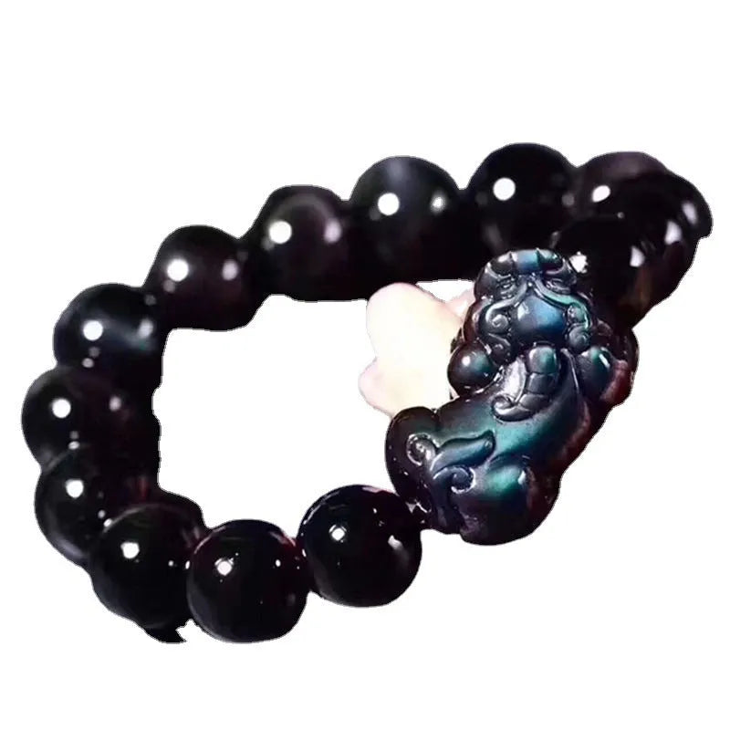 Natural ice colour eye obsidian crystal bracelet with spherical beads on a wrist.