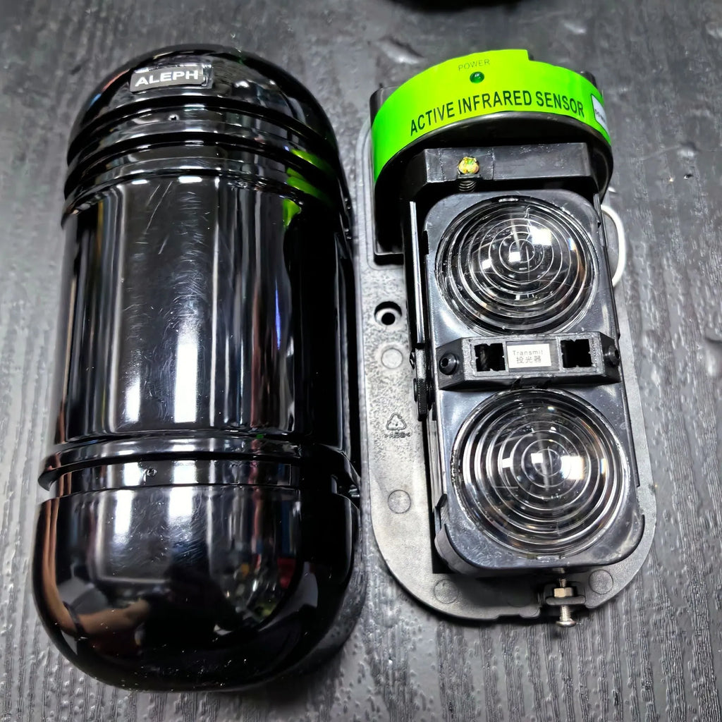 A pair of black wired infrared security detectors for 150-metre perimeter alarm systems.