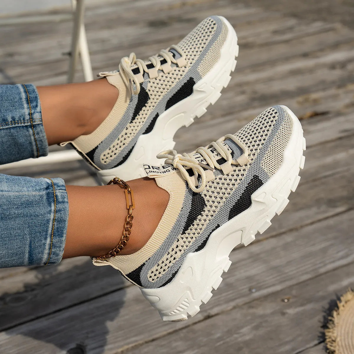 Women's Flyknit mesh lace-up sneaker in a grey colourway, showing the breathable upper and rubber sole.
