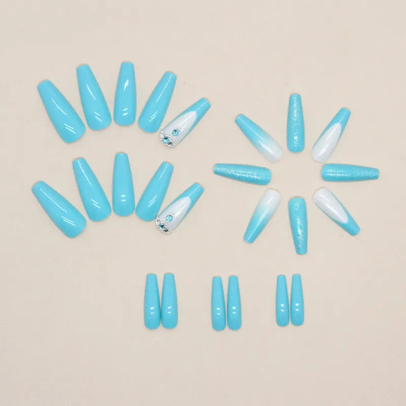 Long solid colour ballet artificial nails with blue diamond glitter glue on a pink background