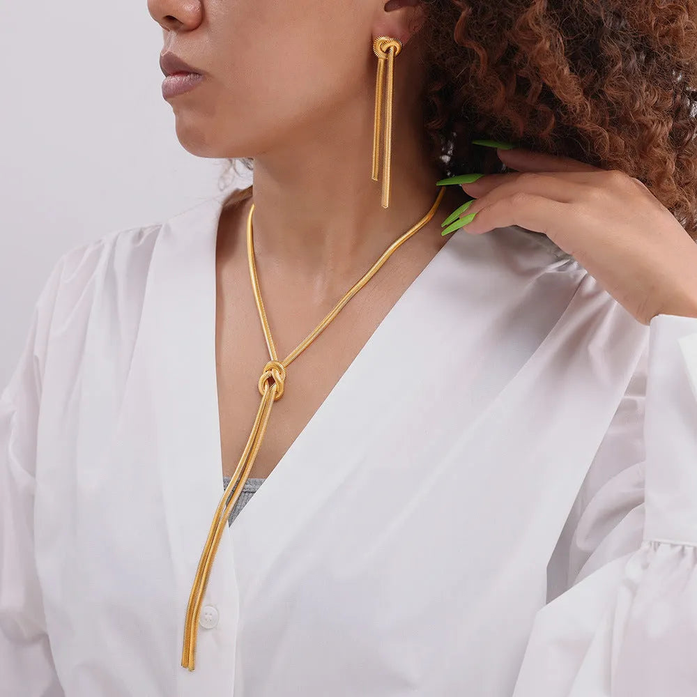 Gold colour knotted tassel pendant on a snake chain necklace with matching electroplated earrings.