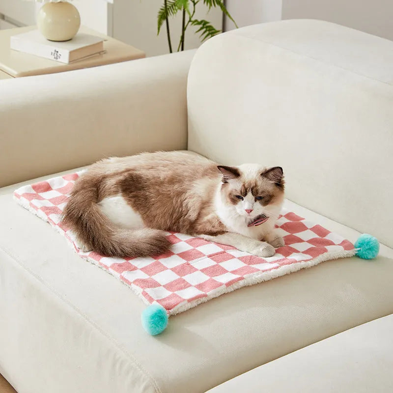 Plush cotton fleece pet blanket with plaid pattern and fur balls in green colour on couch
