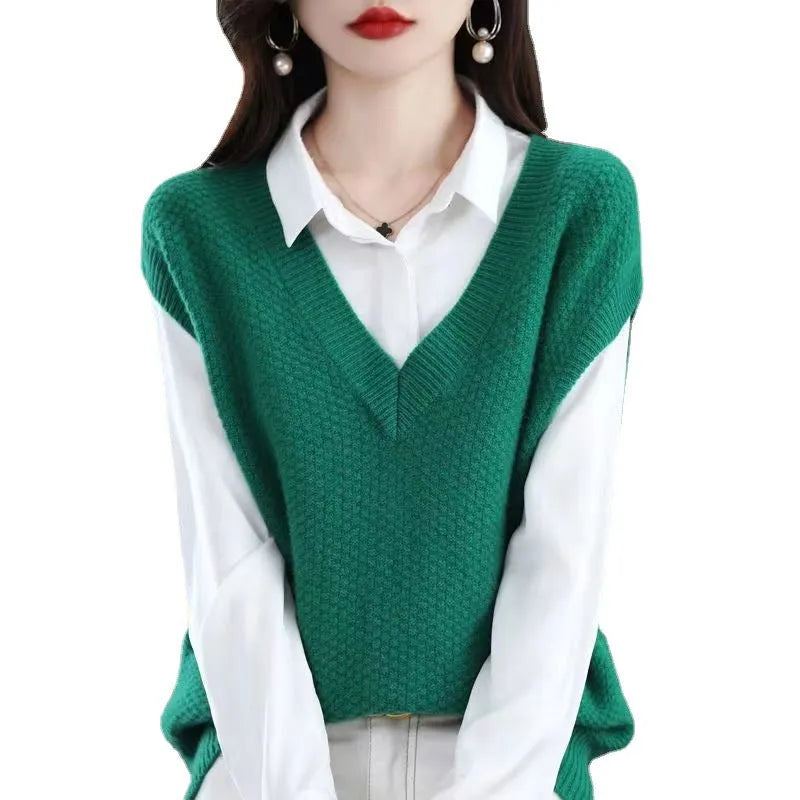 V-neck sleeveless knitted beige vest with a raised 3D pattern, laid flat.