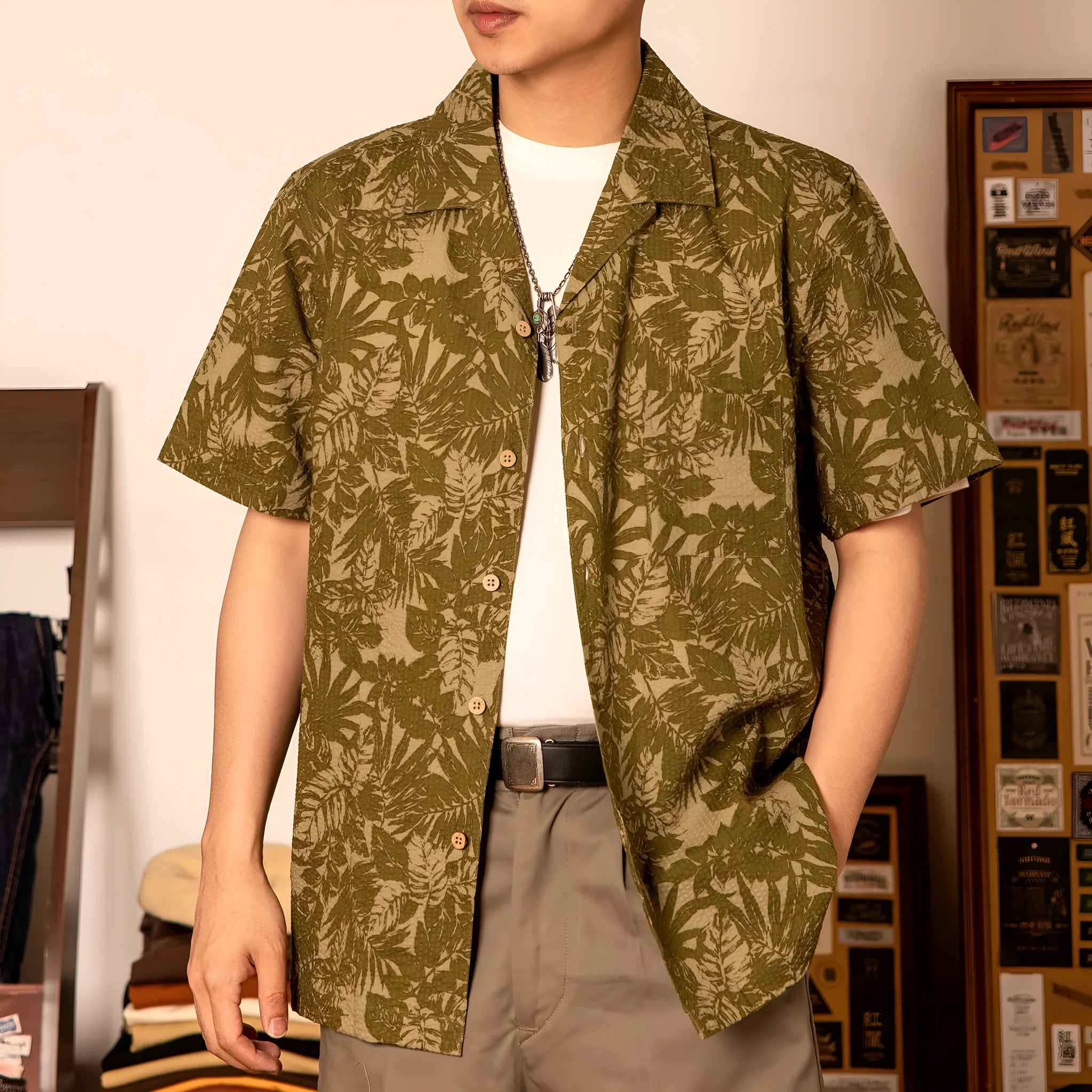 Men's green seersucker shirt with floral print and a Cuban collar, laid flat.