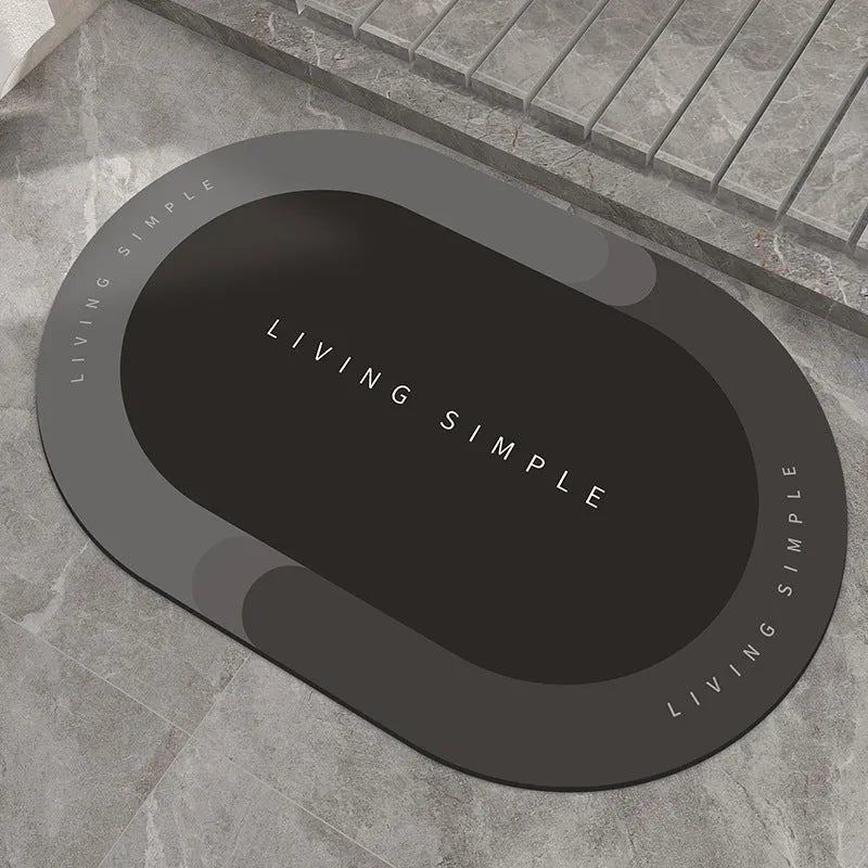 Grey oval super absorbent polyester bath mat with non-slip rubber bottom on tiled floor