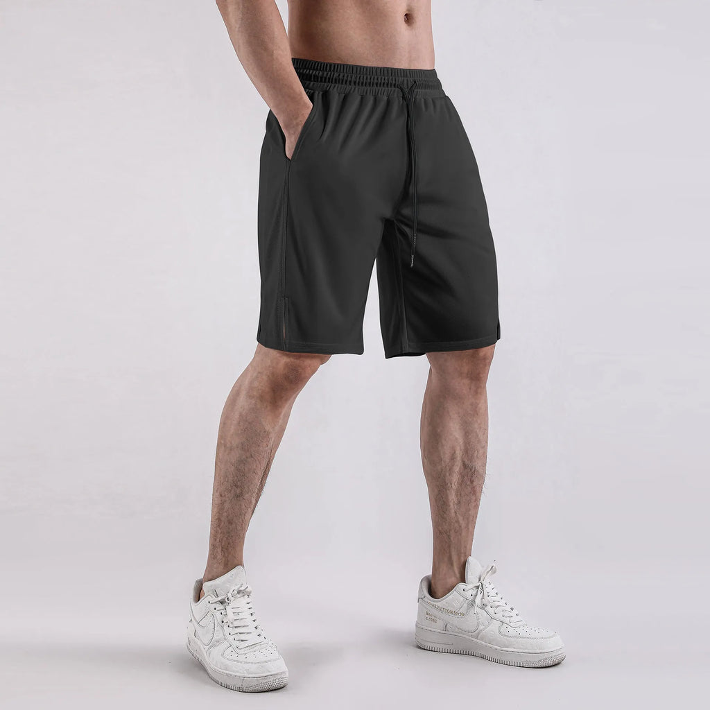 Man wearing black loose-fit quick-dry mesh shorts for summer sports.