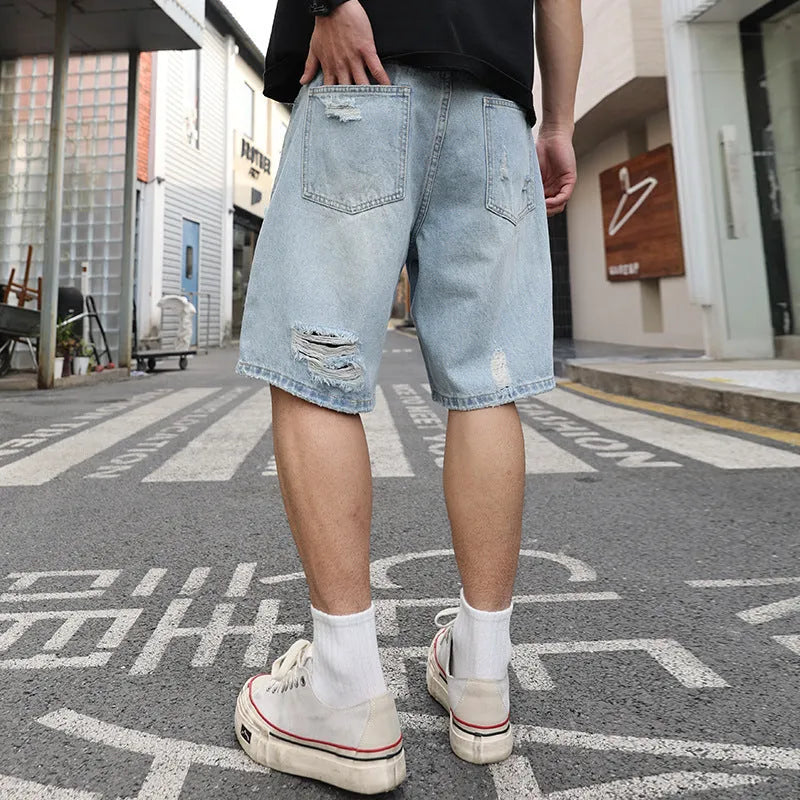 Light blue distressed denim shorts with ripped detailing and straight cut hip hop style