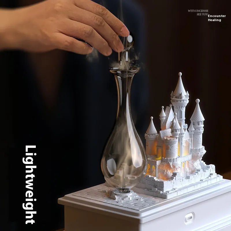 White medieval castle shaped waterless aromatherapy machine with ambient light on a wooden surface.
