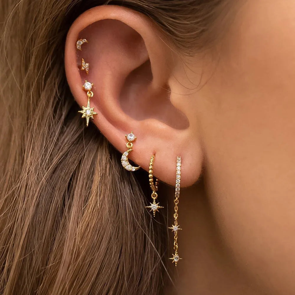 Six pairs of gold electroplated earrings with chain tassel and zircon stud designs representing different months