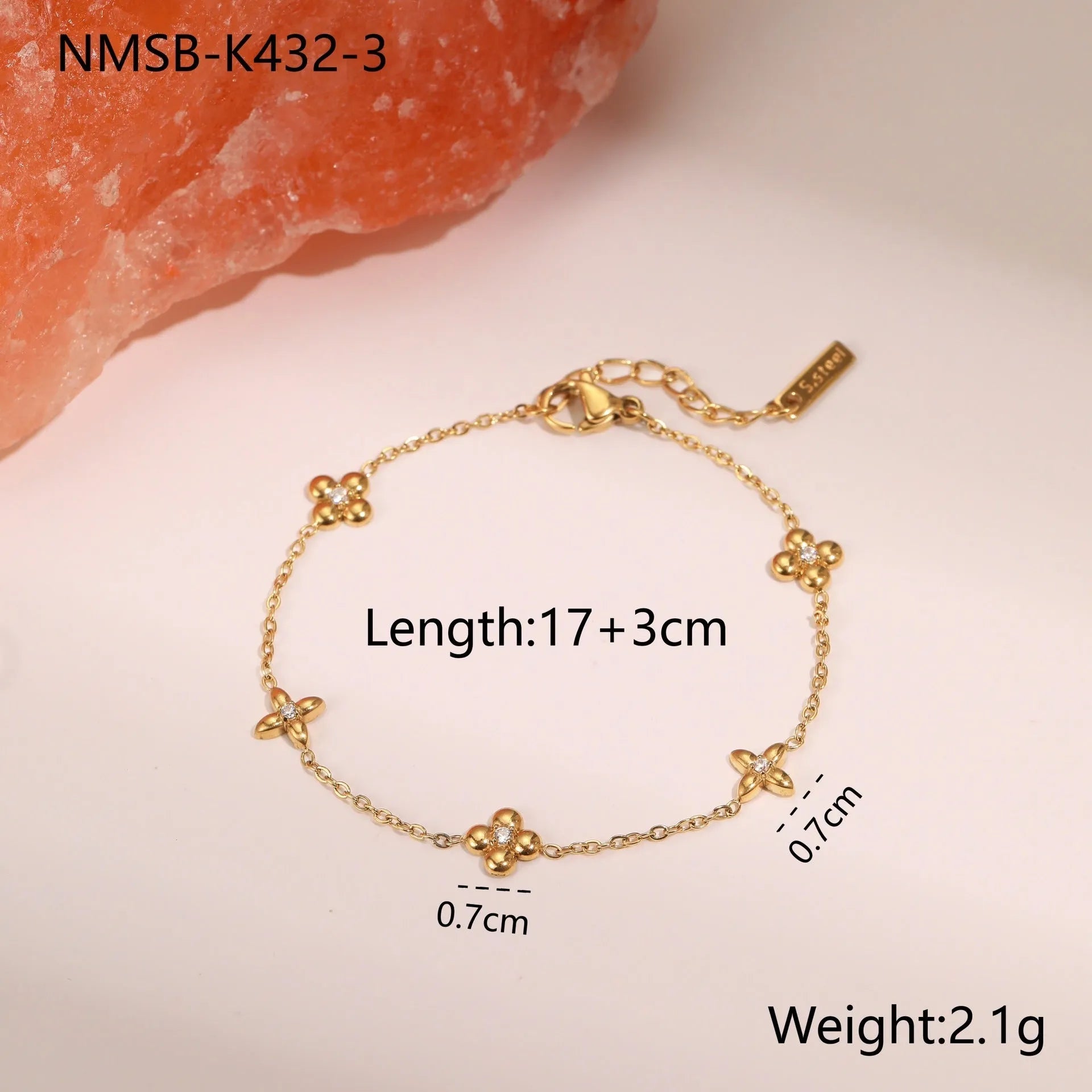 Women's stainless steel bracelet with 18K gold plating and a geometric zircon star pendant on wrist.