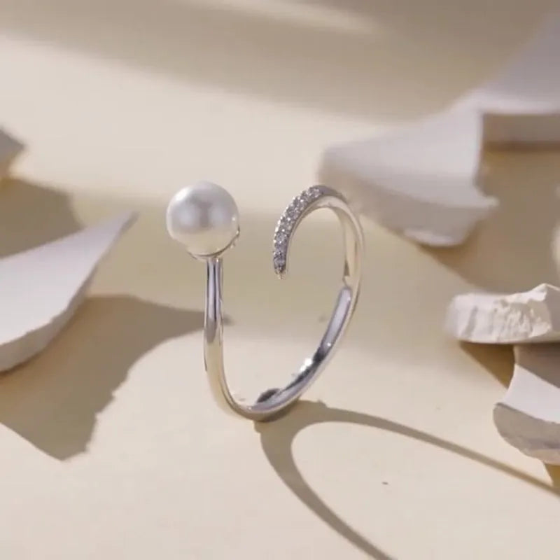Adjustable sterling silver ring with natural shell pearls and open loop design