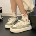 Green women's casual flat-heel sneakers with a mesh upper and round toe.
