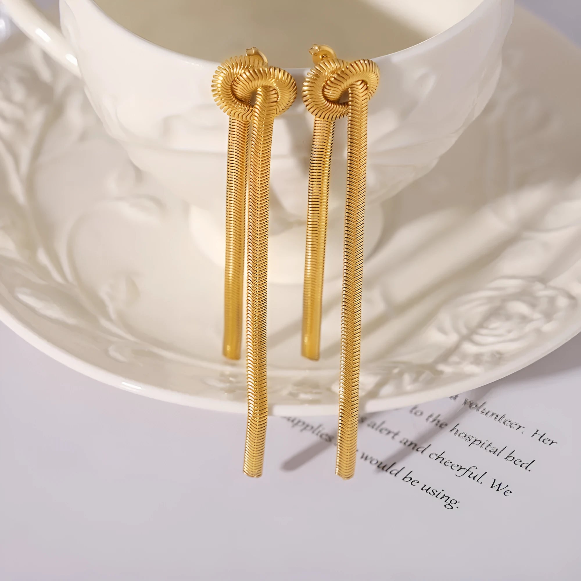 Gold colour knotted tassel pendant on a snake chain necklace with matching electroplated earrings.