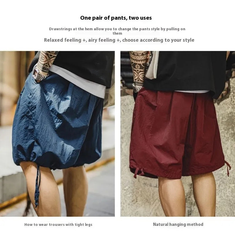 Prussian blue men's loose fit nylon shorts with embroidery on a plain background.