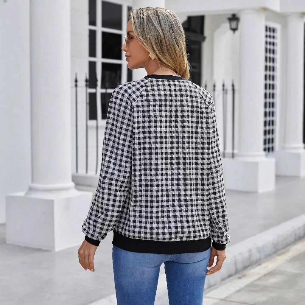 Black long sleeve pullover sweater with printed plaid and stripe pattern.