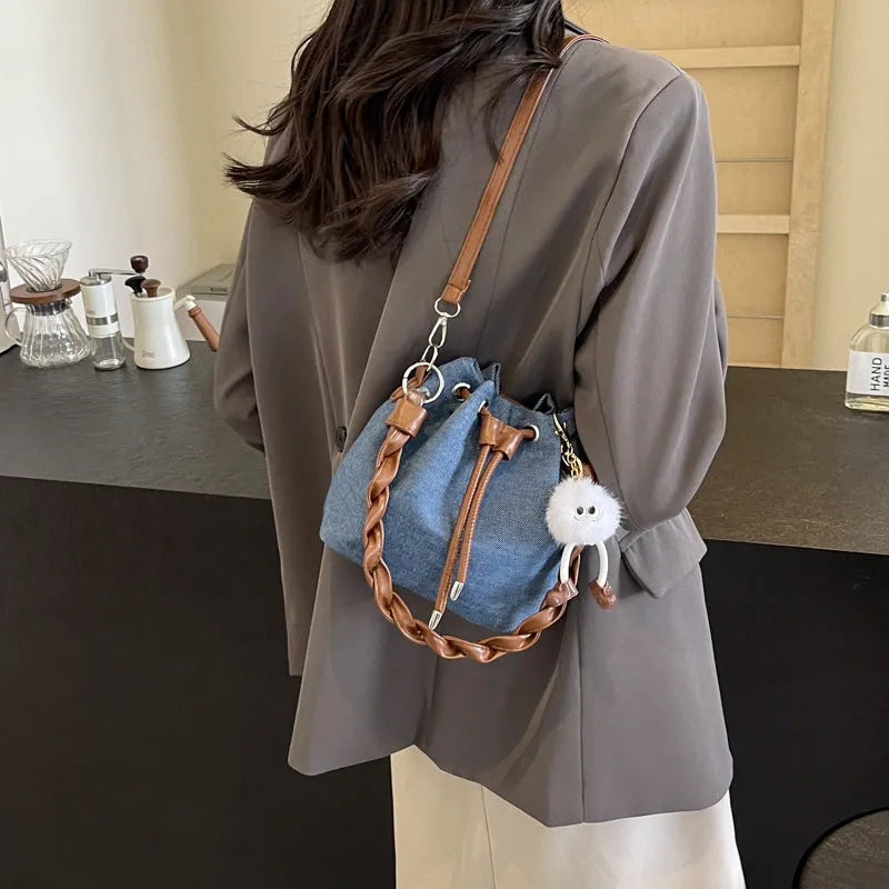Blue cross body bucket messenger bag with synthetic leather construction