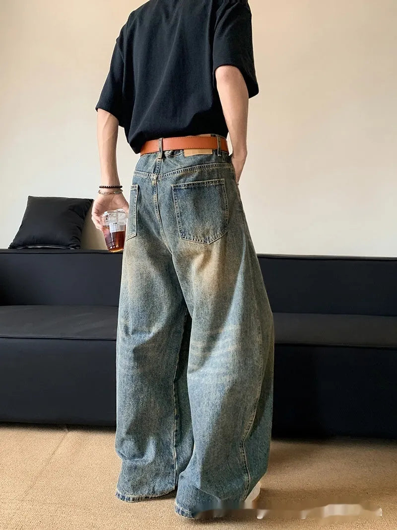 Men's retro blue distressed denim pants with a slim wide-leg fit and a zipper fly.