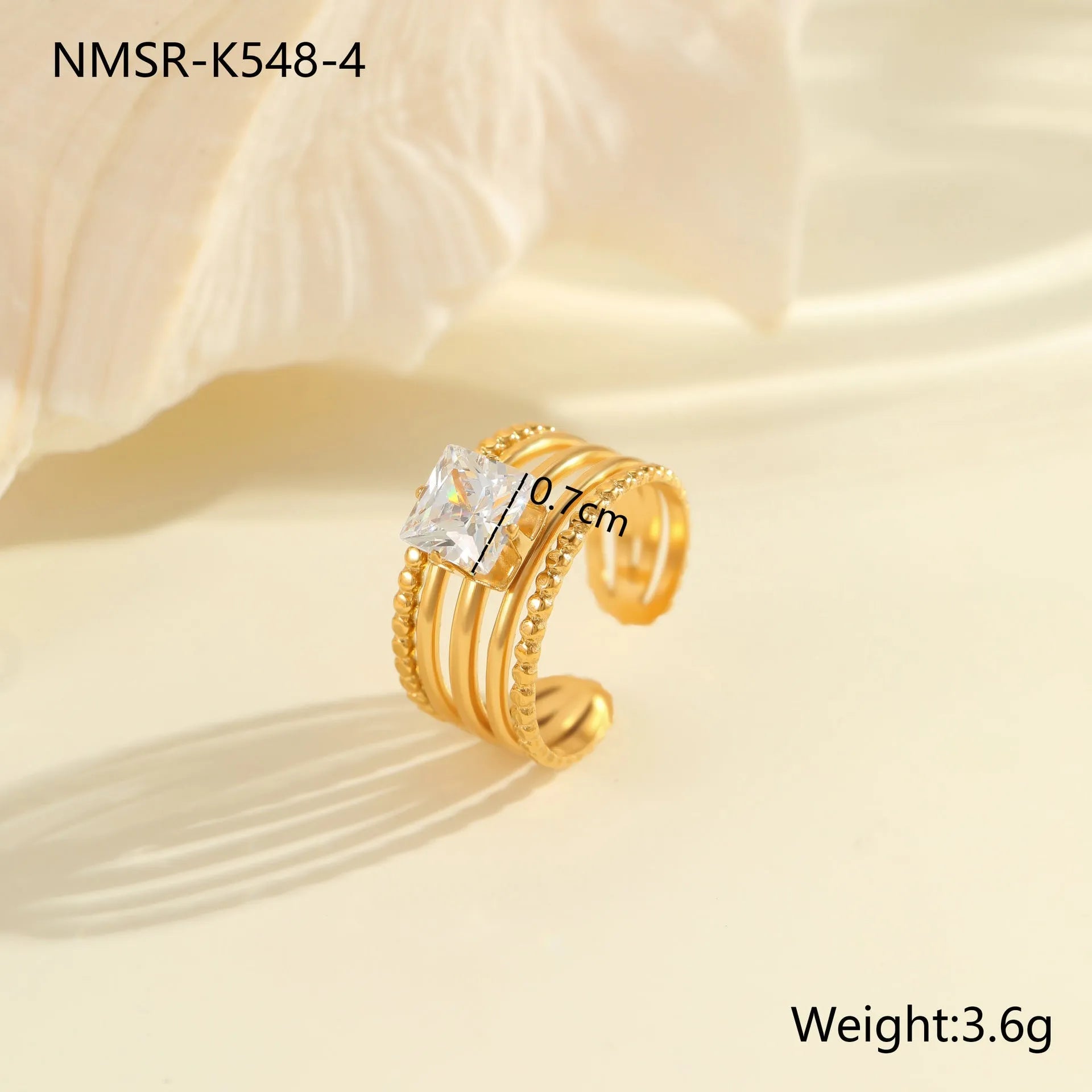 Gold-plated geometric stainless steel ring with inlaid zircon stones on a white background.