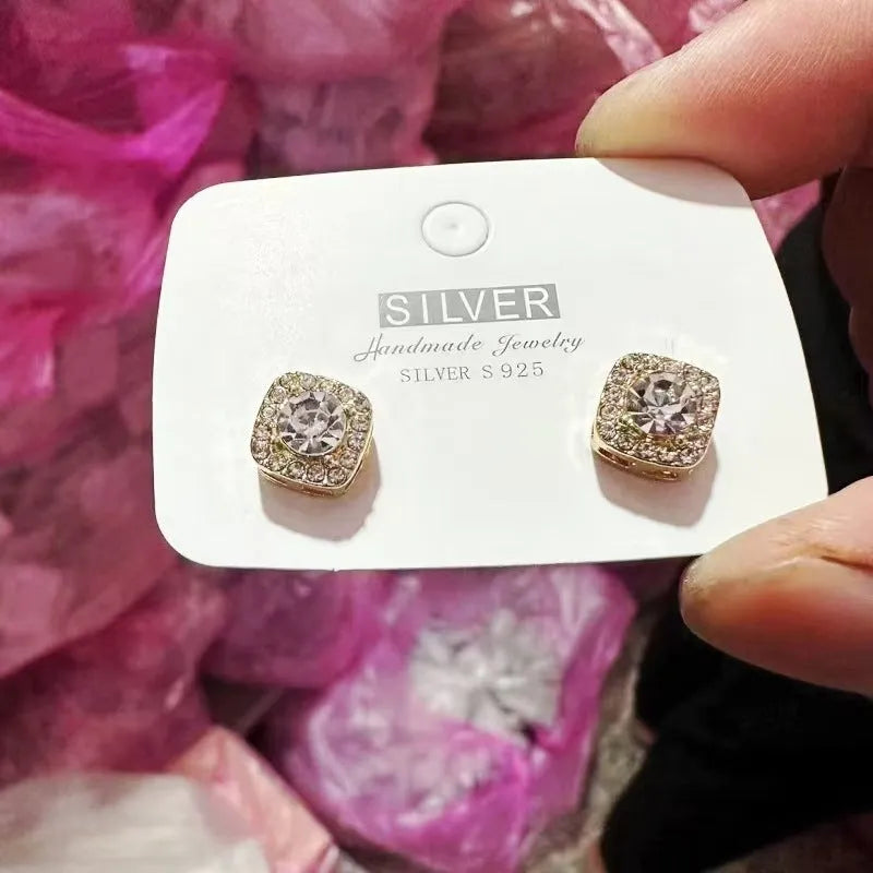 A pair of square-shaped diamond-treated alloy earrings on a white background, showing silver and gold colour options.