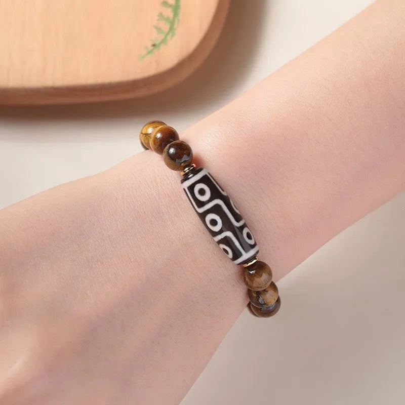 Tigereye Dzi bead single circle Buddha rosary bracelet on a wrist.