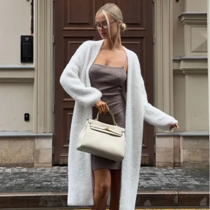 Women's long white knitted cardigan jacket with long sleeves and a loose fit.