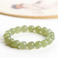 Polished Hetian jade ball bracelet on a wrist, showing ice-like clear beads in one of four available sizes.