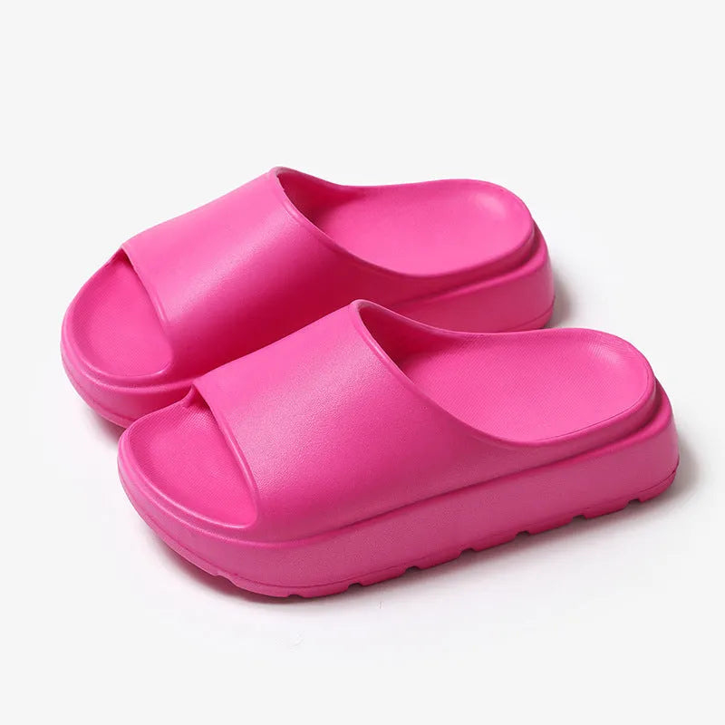 Women's beige thick soled EVA beach slippers with fish mouth design on a wooden floor