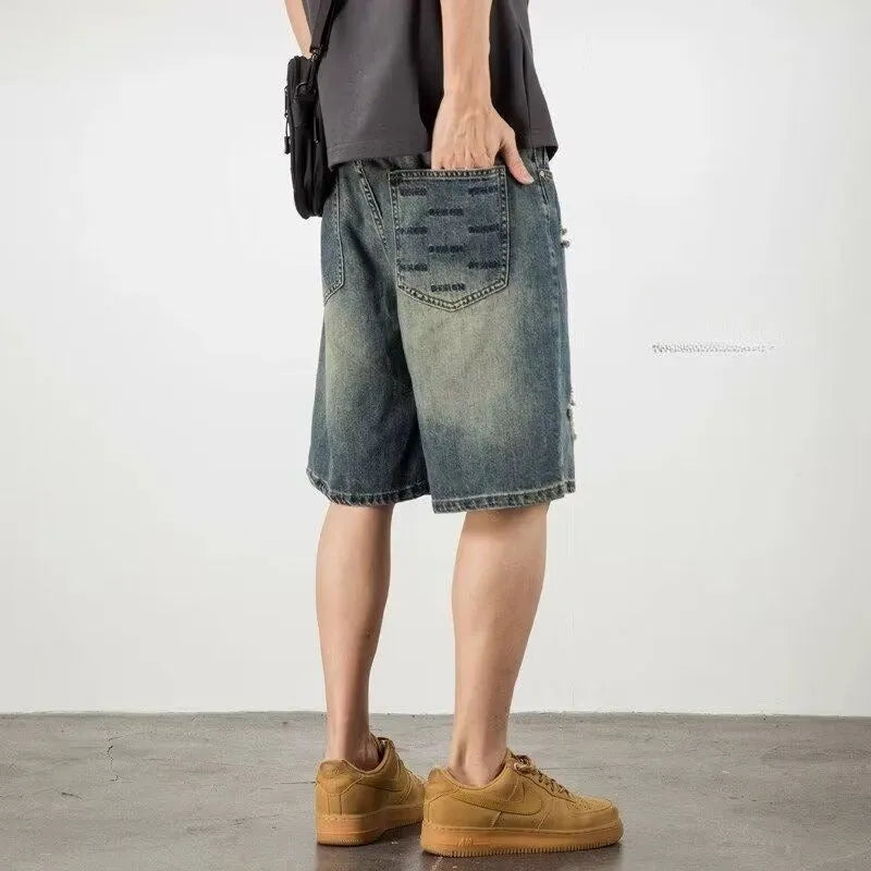 Men's blue denim shorts with loose hole distressing and straight leg silhouette