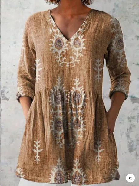 A woman modelling a printed, loose-fitting dress with a wide waist and three-quarter length sleeves.