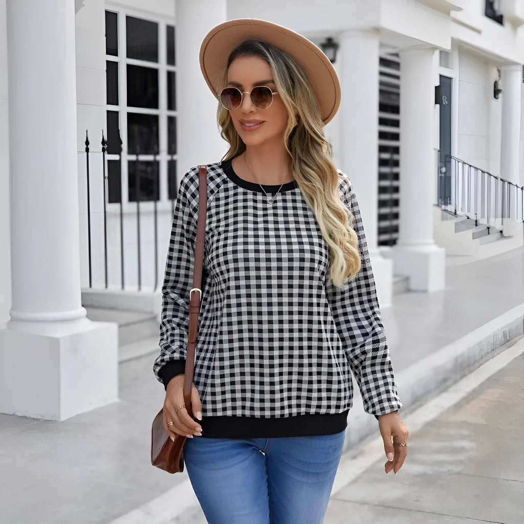 Black long sleeve pullover sweater with printed plaid and stripe pattern.