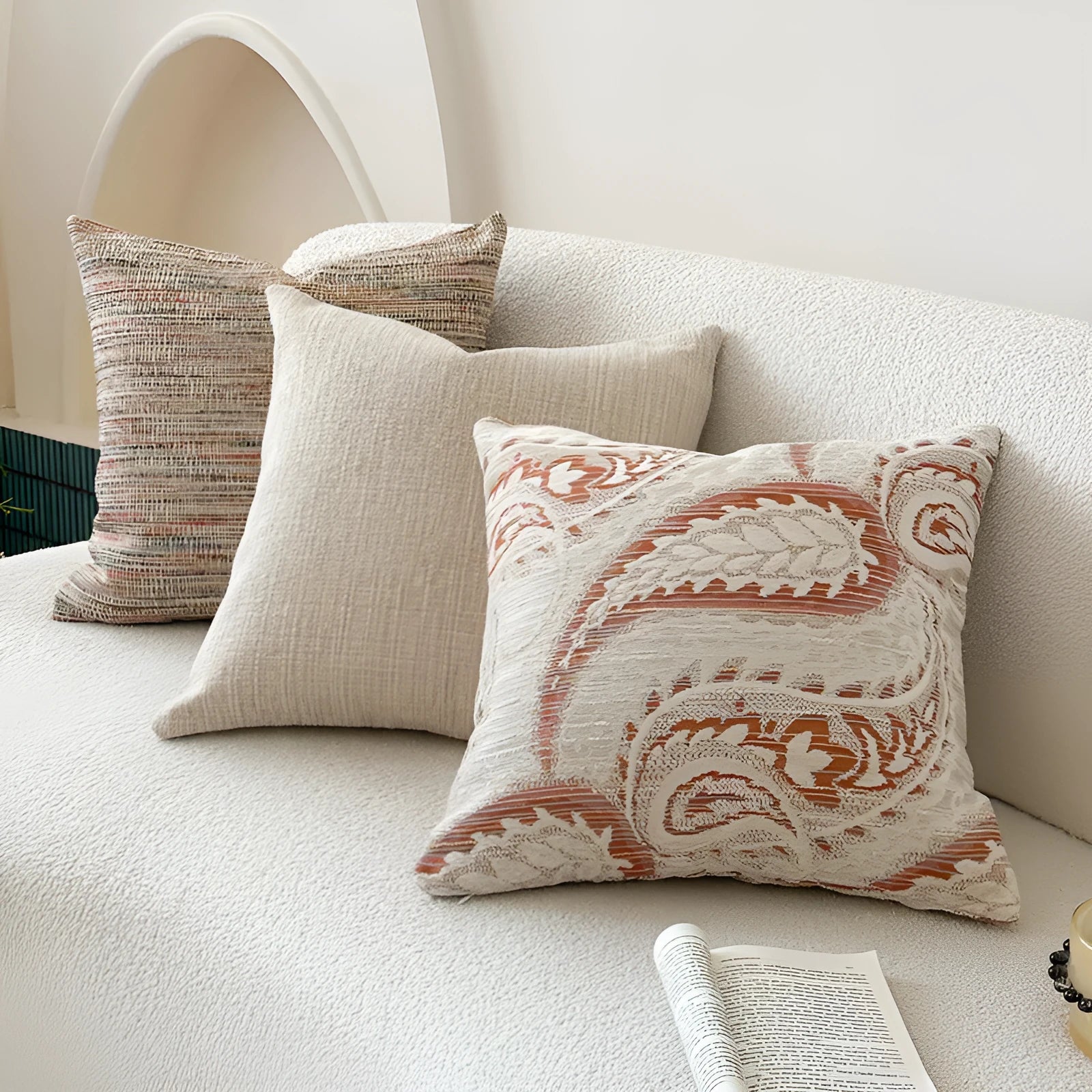 American-style jacquard cushion cover with paisley and flower pattern in amber colours on a sofa.