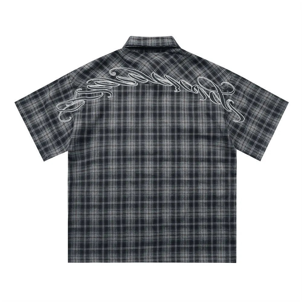 Men's black and brown plaid short sleeve shirt with embroidered letter detailing on the front