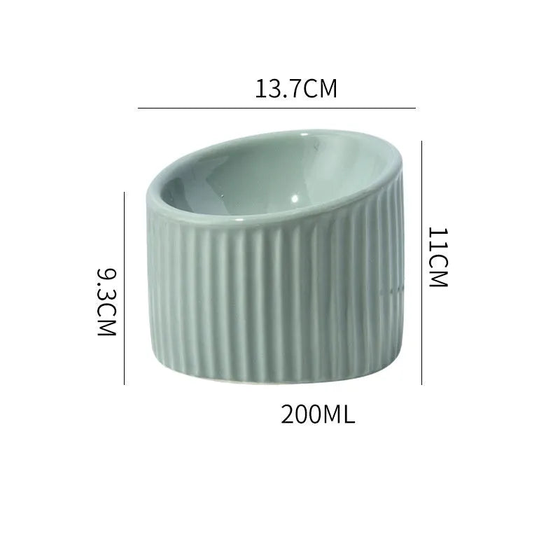 Ceramic elevated cat bowl in green, showing tilted round dish on a raised stand.