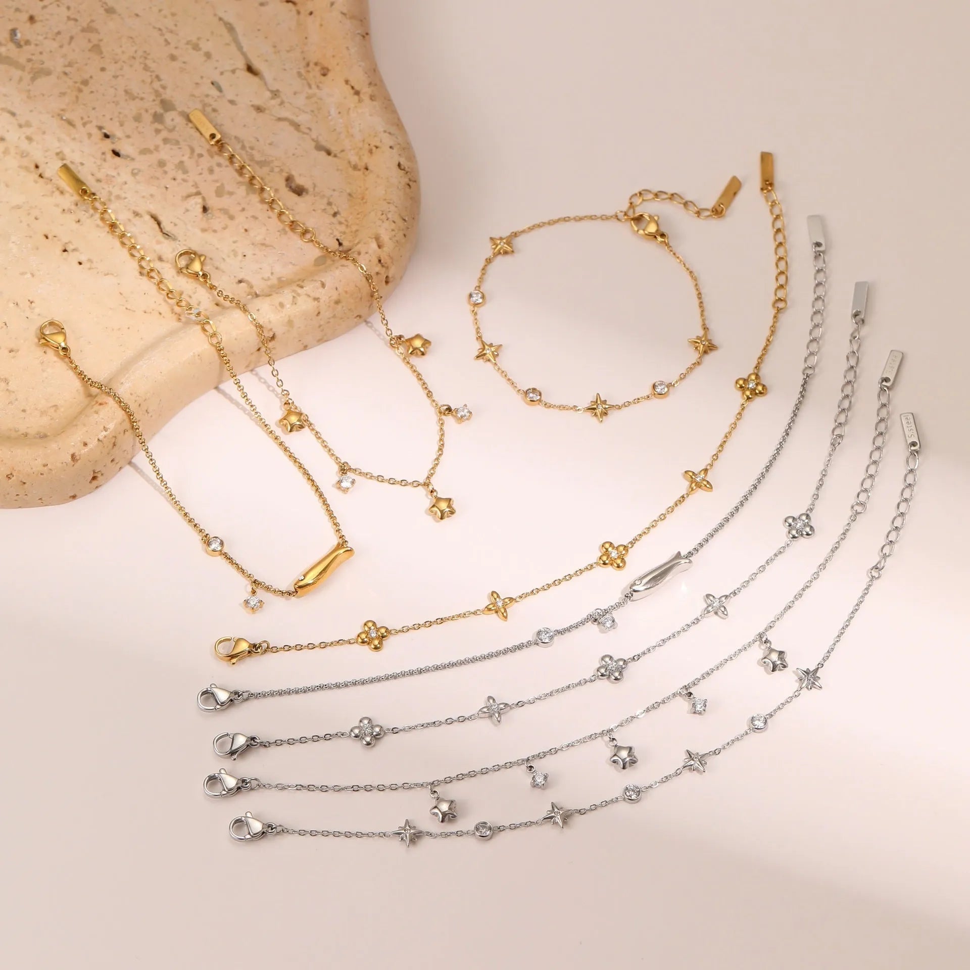 Women's stainless steel bracelet with 18K gold plating and a geometric zircon star pendant on wrist.