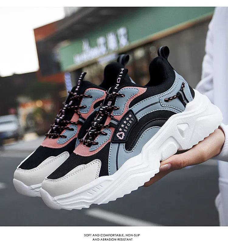Women's white thick-soled casual sneakers with mesh upper and buckle detail on a light background.