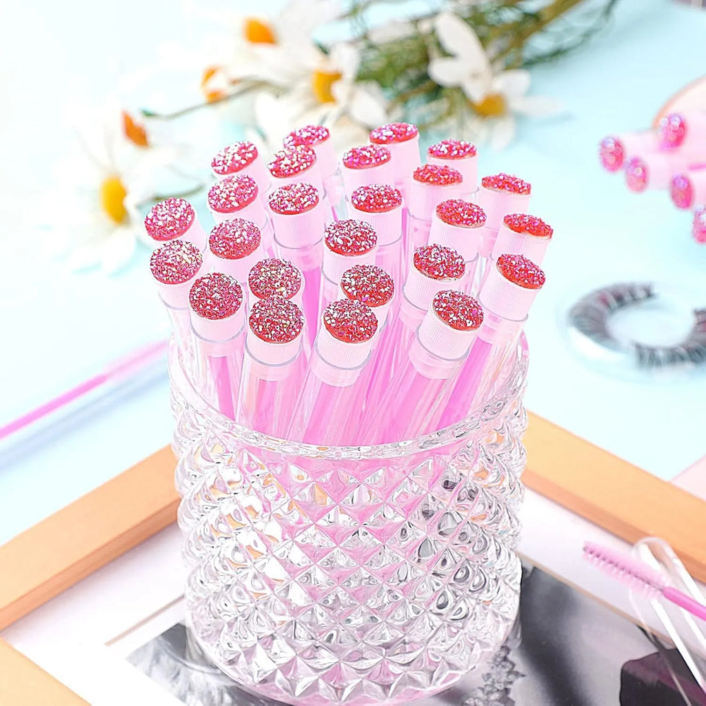 Disposable mascara brushes in protective transparent tubes with spiral brush heads in blue, green, pink, and purple colours