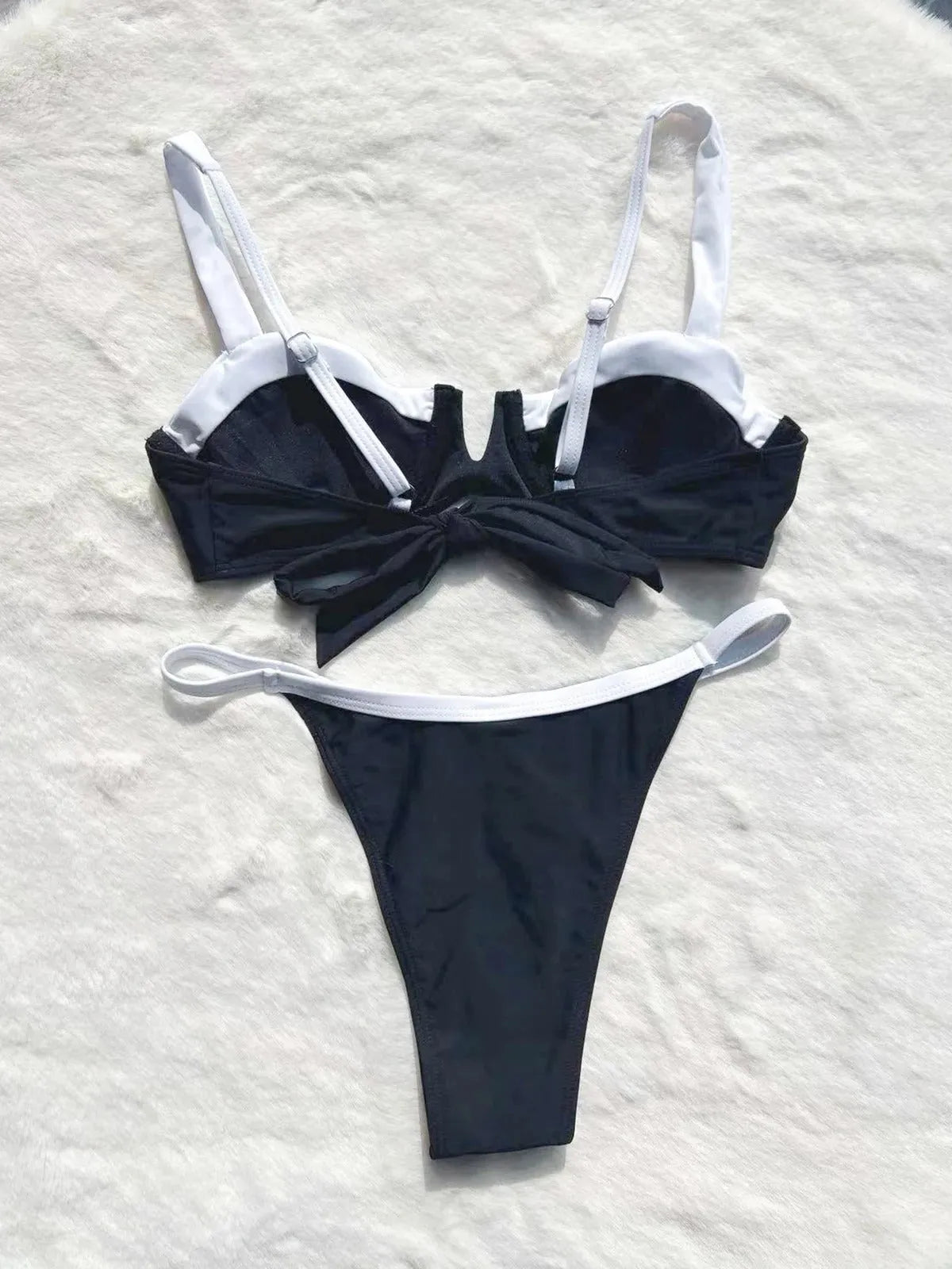 Black low-waist women's bikini swimsuit with stitching detail on a mannequin