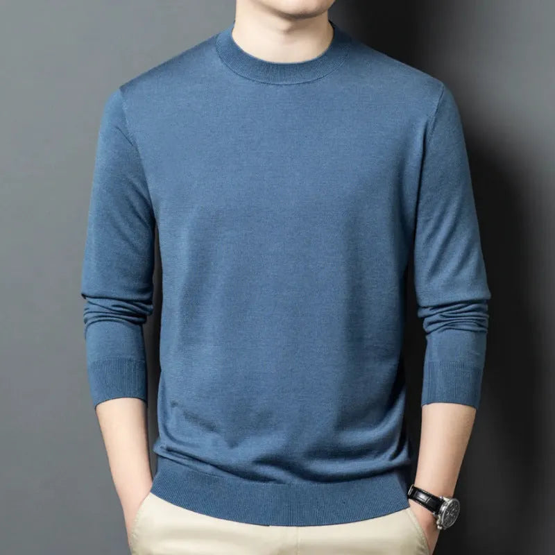 Man wearing a round neck long sleeve wool blend pullover sweater in a neutral colour.
