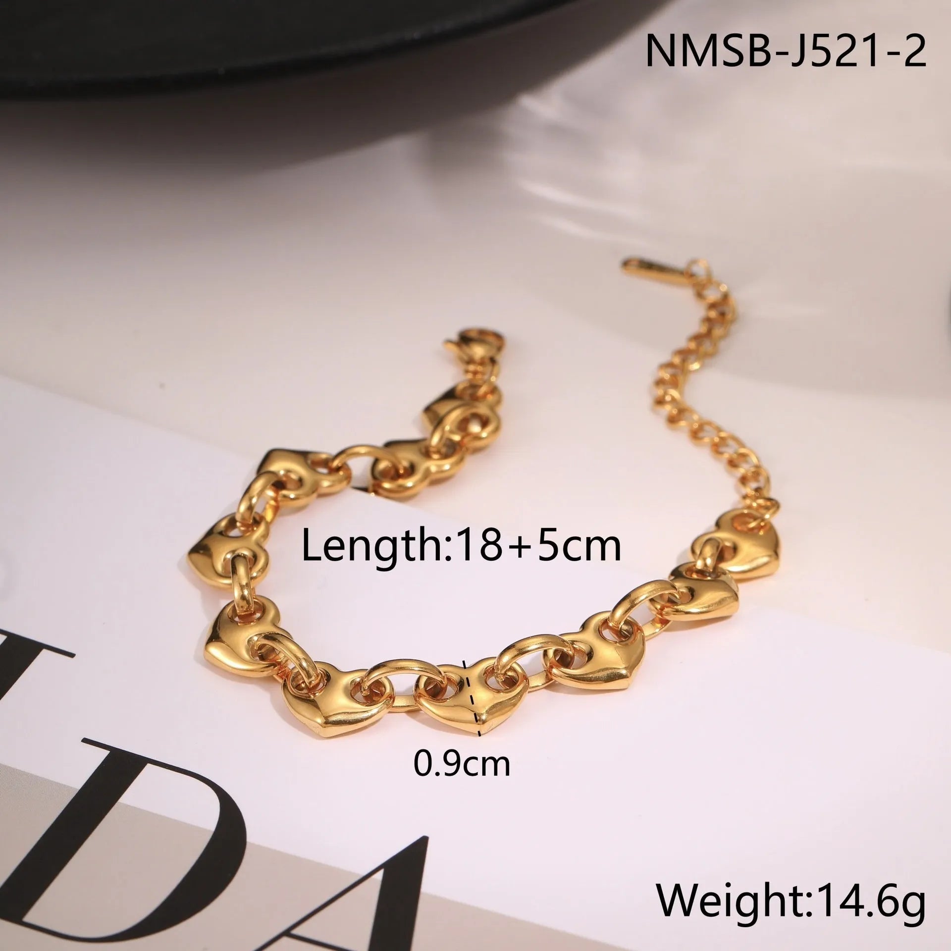 Stainless steel bracelet with a hollowed-out heart charm in a gold electroplated finish.