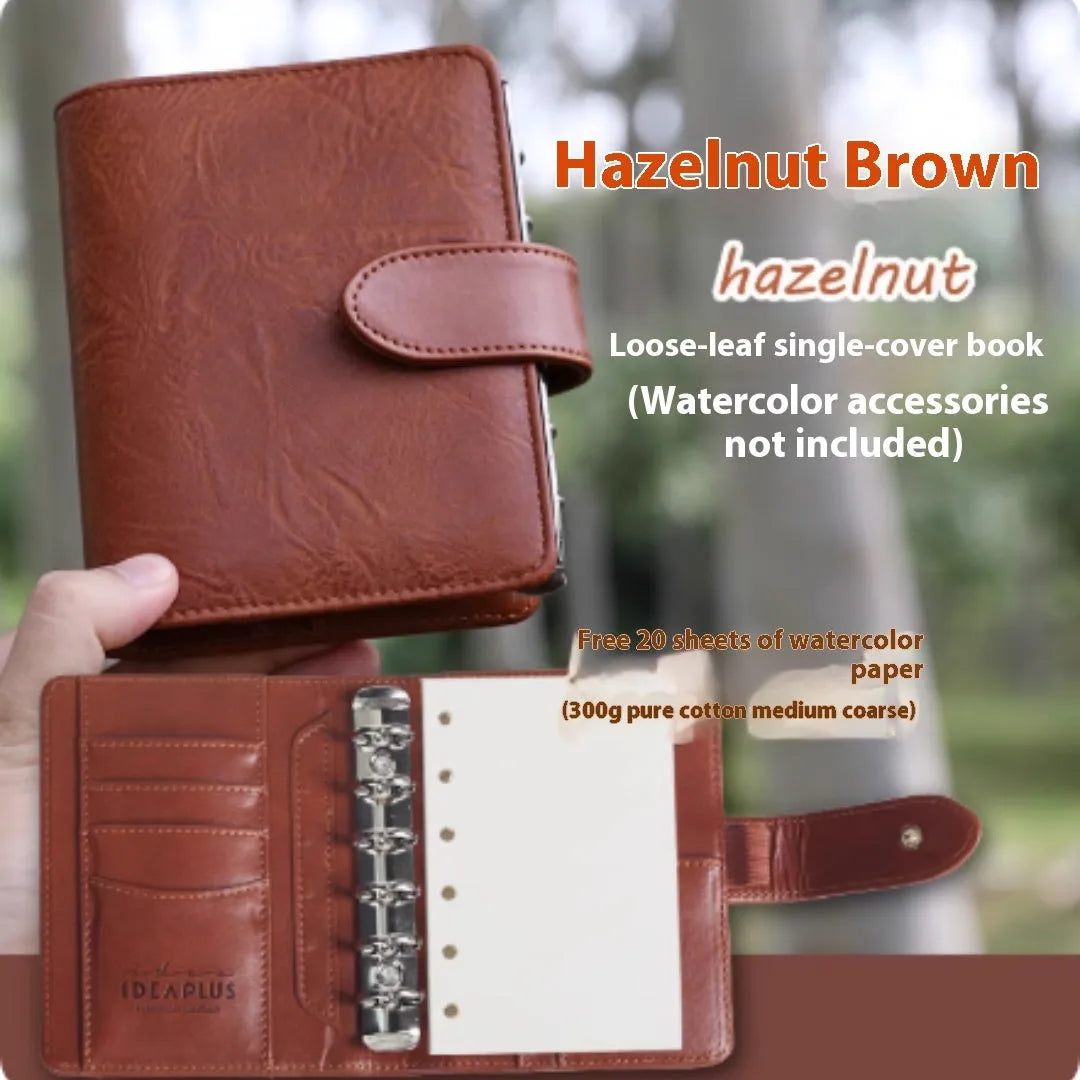 A7 format loose-leaf watercolour notebook in green, shown open on a page with a watercolour wash.