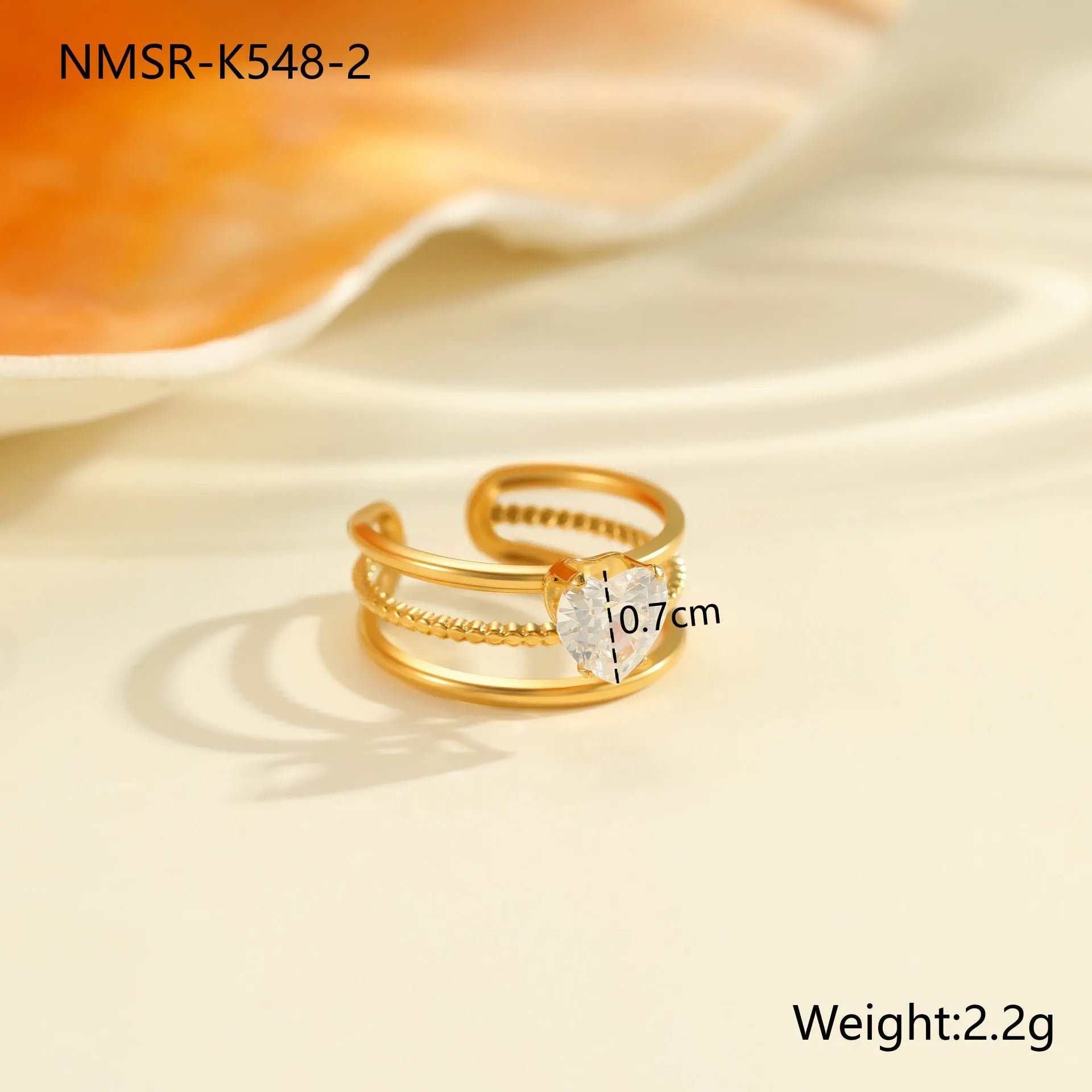Gold-plated geometric stainless steel ring with inlaid zircon stones on a white background.