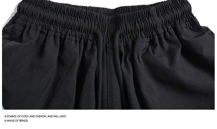 Quick-drying black and grey sports shorts with elastic waist and loose straight-leg design