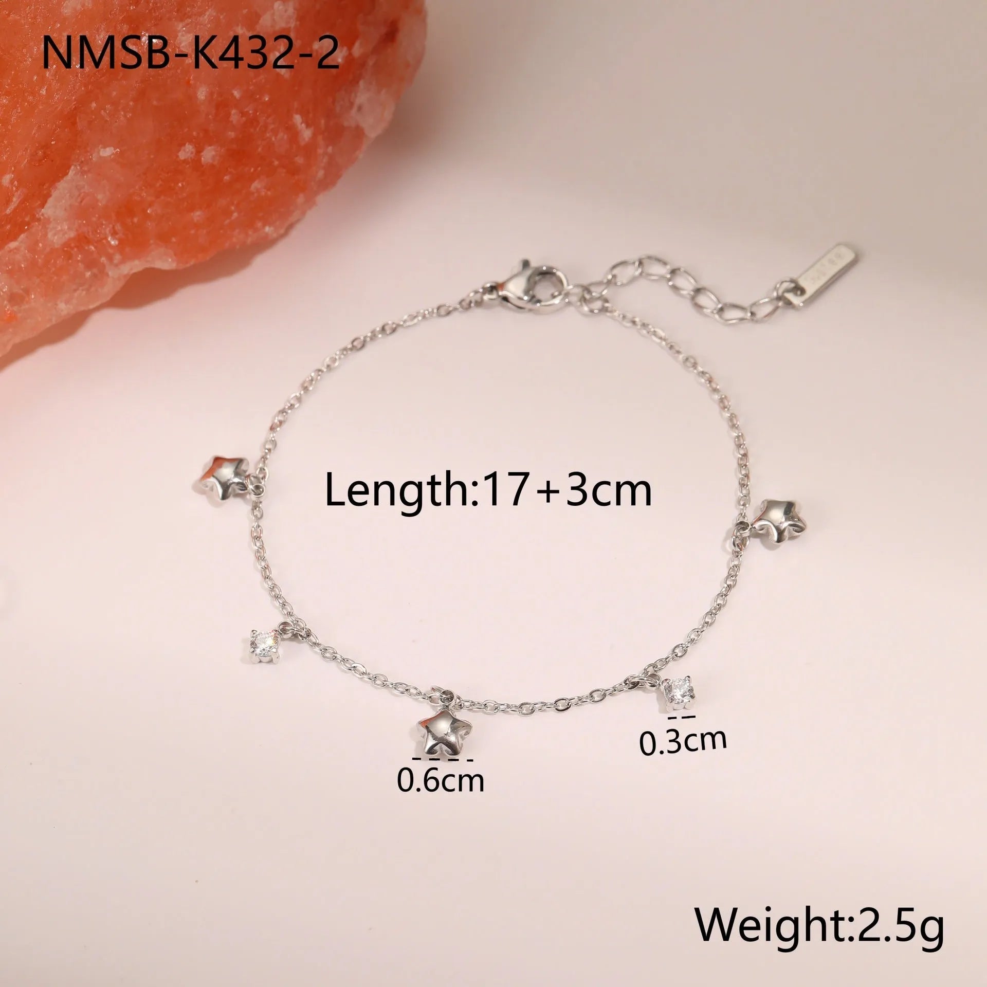 Women's stainless steel bracelet with 18K gold plating and a geometric zircon star pendant on wrist.